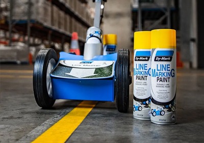 Yellow warehouse line markings guiding forklift and pedestrian traffic in a busy industrial facility